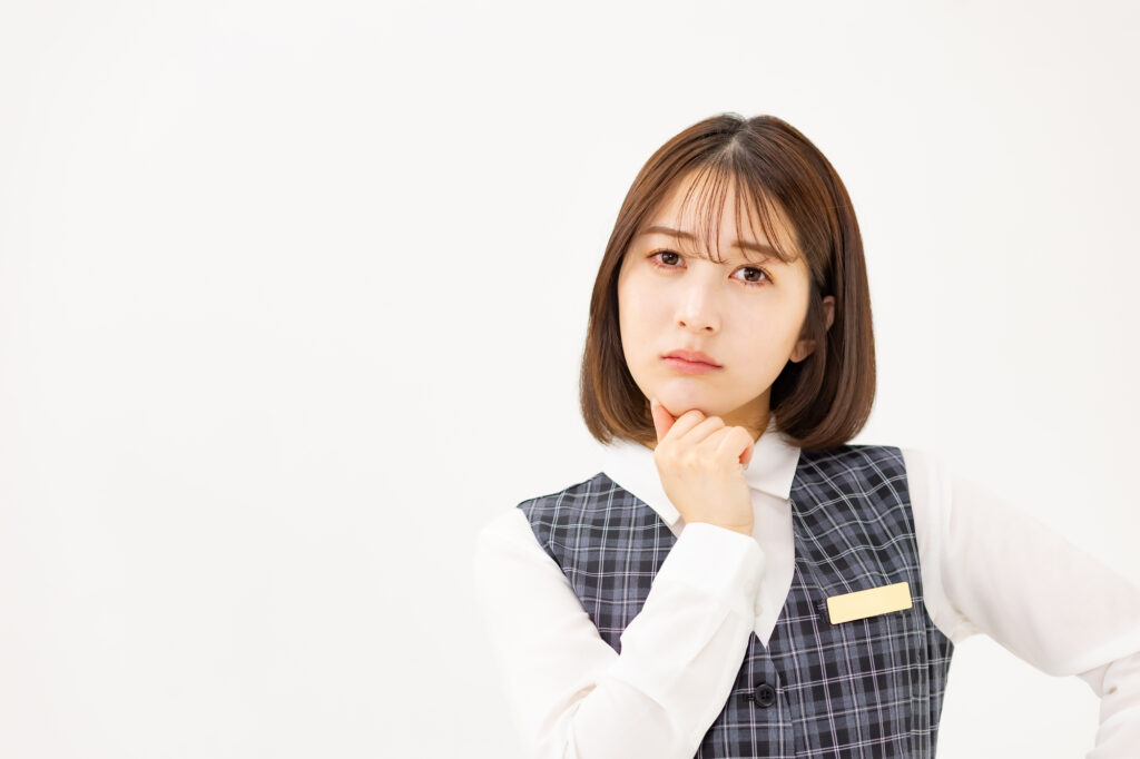 働きながら悩んでいる制服の女性