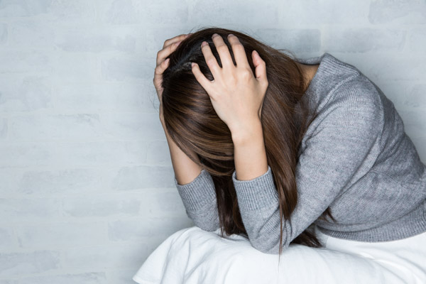 パワハラを受け頭を抱えている女性